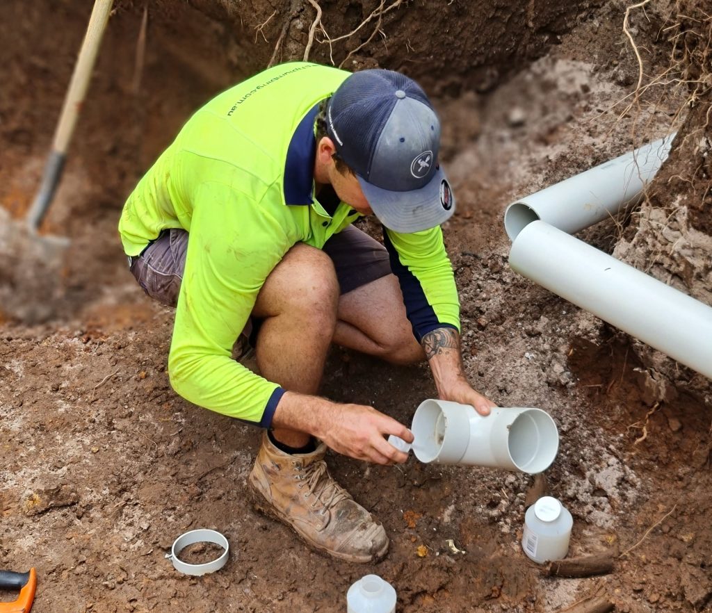 Plumber from Jaetech sealing a burst pipe in the yard of a Darwin home.
